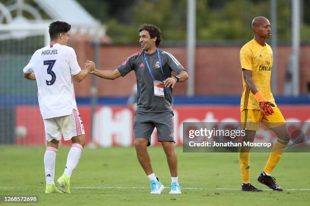 Raul Gonzalez Blanco Head coach of Real Madrid shakes hands with Miguel Gutierrez after the final whistle as Leobrian Kokubo of Benfica walks off in...