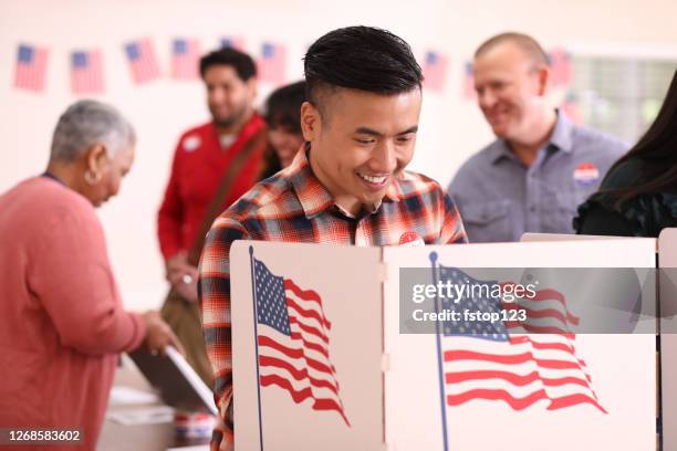 el hombre de ascendencia asiática de mediana edad vota en las elecciones de estados unidos. - pueblos de asia oriental fotografías e imágenes de stock