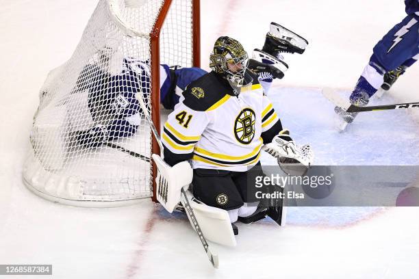 Blake Coleman of the Tampa Bay Lightning falls into the net after scoring a goal past Jaroslav Halak of the Boston Bruins during the first period in...