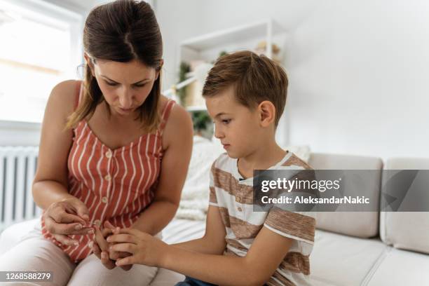 woman taking her son's blood sugar level - hypoglycemia stock pictures, royalty-free photos & images