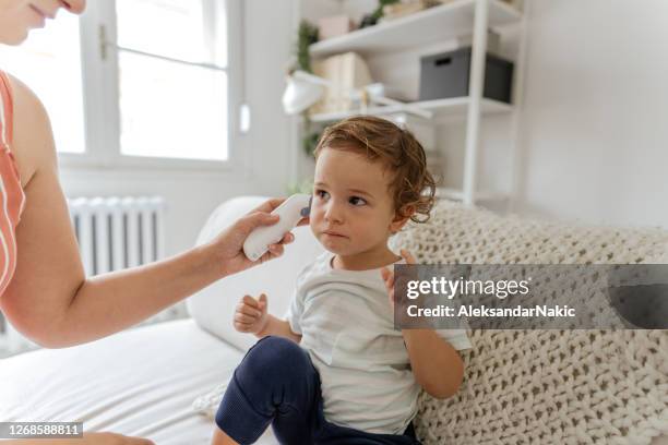 lichaamstemperatuurcontrole met een oorthermometer - ear stockfoto's en -beelden