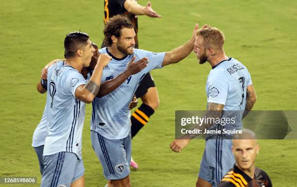Johnny Russell of Sporting Kansas City is congratulated by Graham Zusi and Alan Pulido after scoring during the 1st half of the game against the...