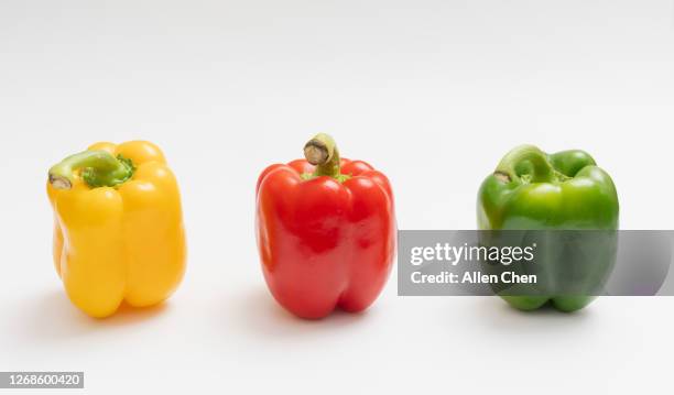 green, yellow and red peppers on a white background - yellow bell pepper stock pictures, royalty-free photos & images