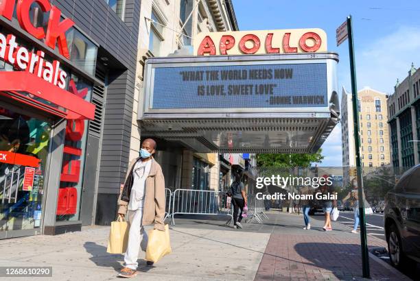 Person wears a protective face mask outside Apollo Theater in Harlem as the city continues Phase 4 of re-opening following restrictions imposed to...