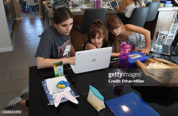 College of Southern Nevada student Jordyn Leal tutors Goolsby Elementary School second graders Ella Dweck and Odette Conrad, both 7, as they take an...