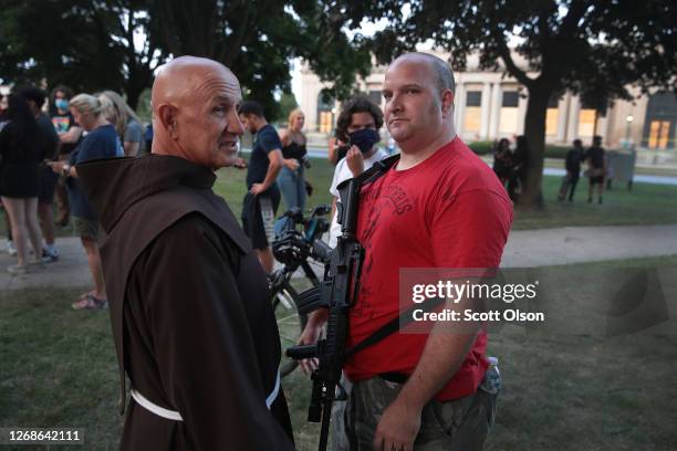 Residents confront protestors near the Kenosha County Courthouse during a third night of unrest on August 25, 2020 in Kenosha, Wisconsin. Rioting as...