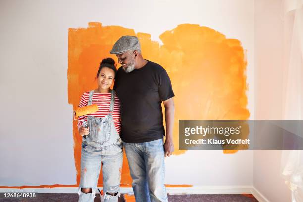 happy family renovating home - pantaloni arancioni foto e immagini stock