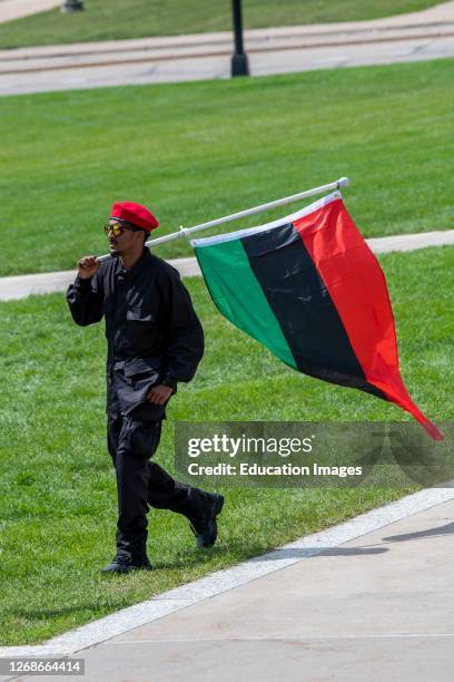 St. Paul, Minnesota, A New Black Panther member walking with the Pan-African flag while attending a rally to end violence.
