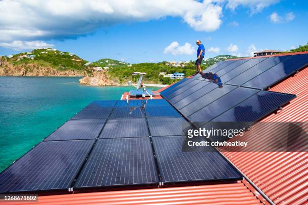 werknemers die zonnepanelen installeren op een villadak in het caribisch gebied - zonne eiland stockfoto's en -beelden