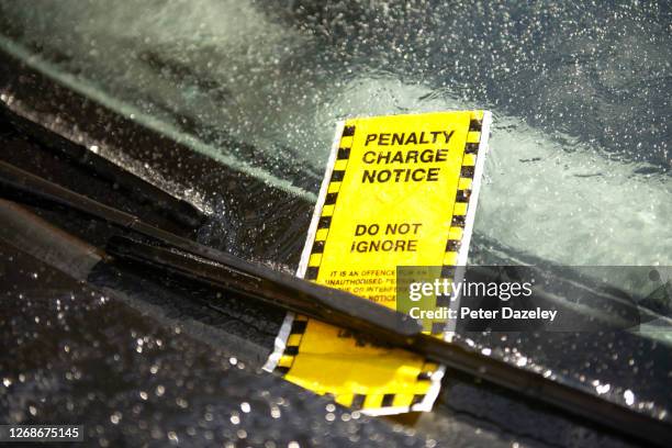 parking ticket on car in rain - parkvergehen-strafzettel stock-fotos und bilder