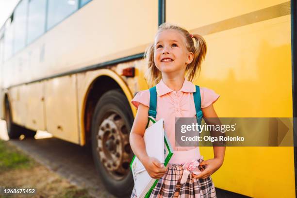 toddler with books beside school bus - first day of school bildbanksfoton och bilder