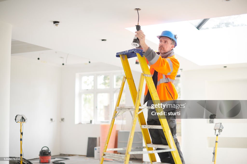 Electrician installing downlights