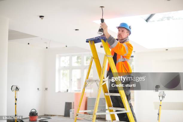 electrician installing downlights - home ceiling lights stock pictures, royalty-free photos & images