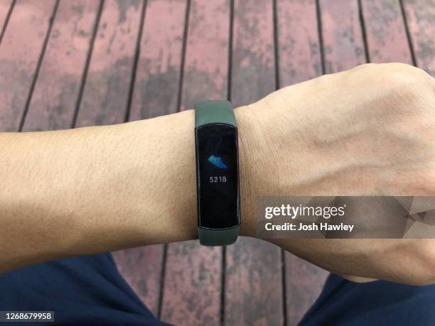 a man looking at a smart sports bracelet after exercising - bracelet ストックフォトと画像