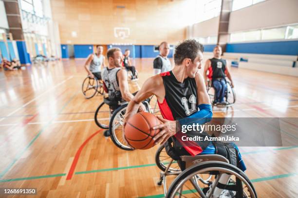 rollstuhl-basketball-aktion während des trainingsspiels - sportler mit behinderung stock-fotos und bilder