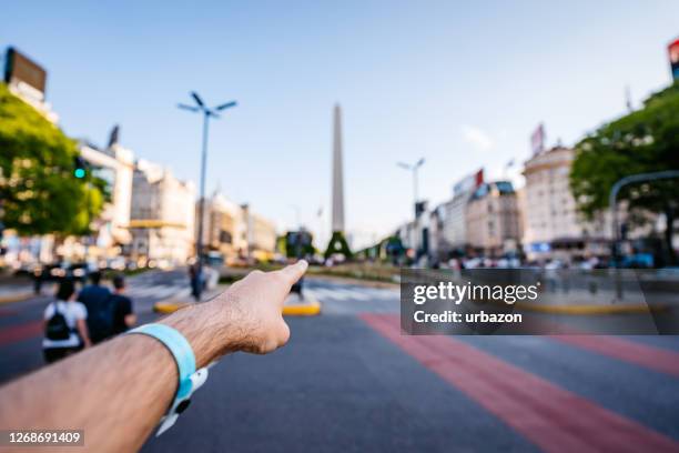 apontando o dedo para o obelisco de buenos aires - obelisco de buenos aires - fotografias e filmes do acervo