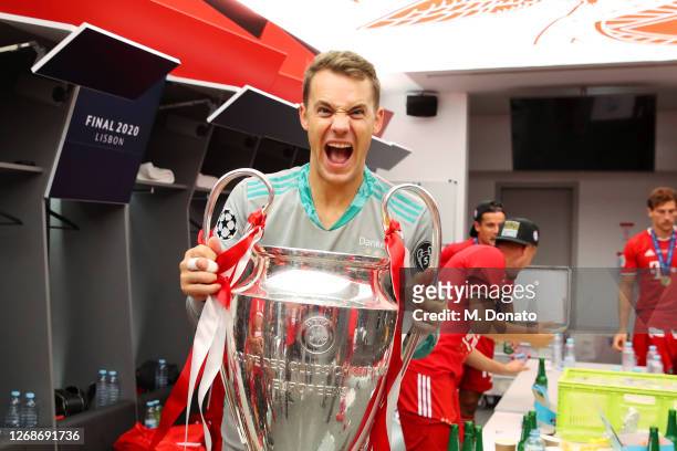 Goalkeeper Manuel Neuer of FC Bayern Muenchen poses with the trophy in the dressing room following his team's victory in the UEFA Champions League...