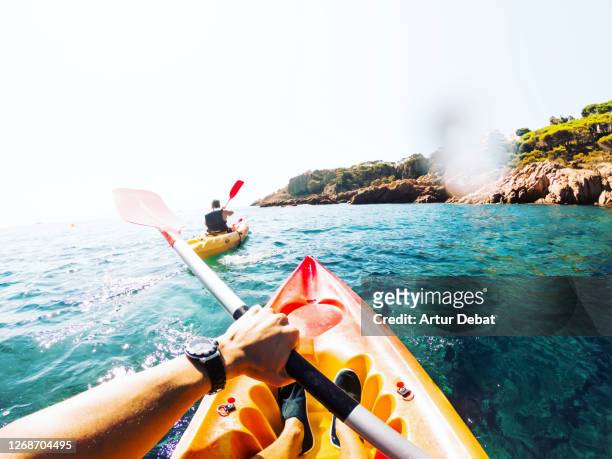 doing kayak from personal perspective with friend in the beautiful hidden corners of girona costa brava in spain during summer of 2020. - kajak stock-fotos und bilder