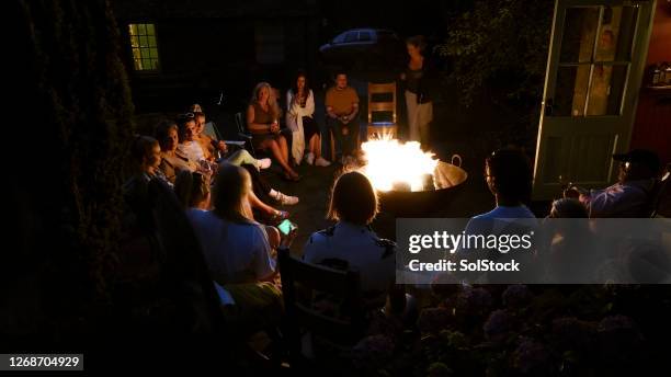 gathering around the fire pit - fire pit stock pictures, royalty-free photos & images