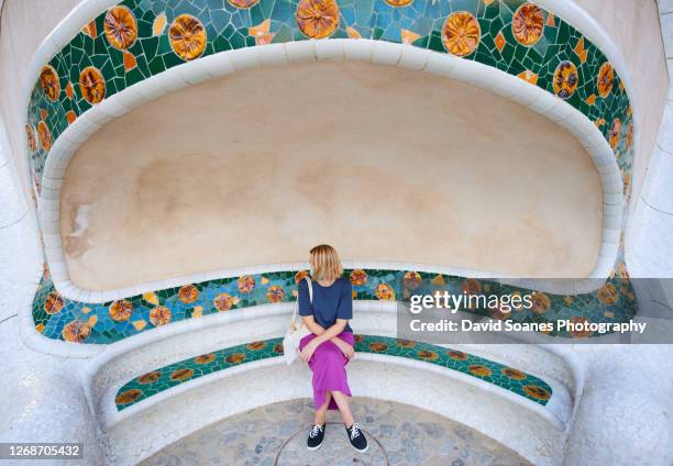 a single tourist in the monumental zone of park guell in barcelona, spain - park guell stock pictures, royalty-free photos & images