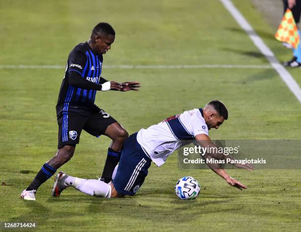 Romell Quioto of the Montreal Impact challenges Lucas Cavallini of the Vancouver Whitecaps during the first half of the MLS game at Saputo Stadium on...