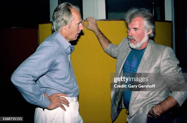 British record producer George Martin and American Country musician Kenny Rogers talk together during Roger's birthday luncheon at RCA Studios,, New...