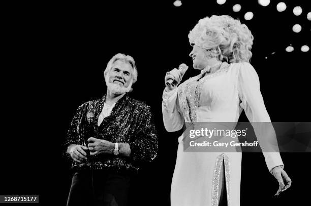 American Country musicians Kenny Rogers and Dolly Parton perform together onstage during a performance at Nassau Coliseum, Uniondale, New York,...