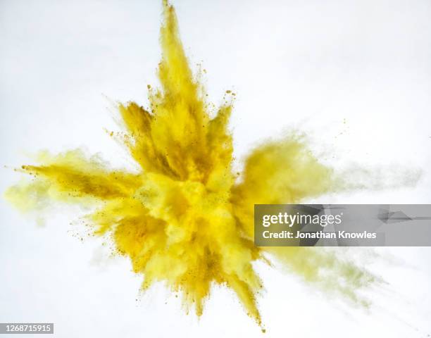 vibrant yellow powder explosion - colored powder stock pictures, royalty-free photos & images