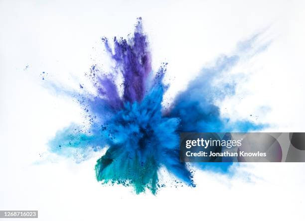 vibrant blue and purple powder explosion - green smoke on white foto e immagini stock