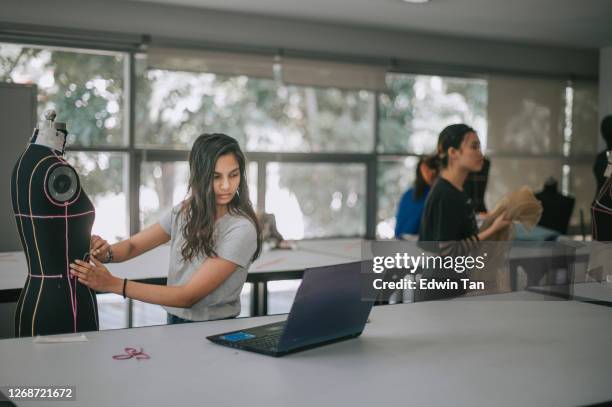 college fashion student attending class in the classroom working on their fashion design project with mannequin - design students stock pictures, royalty-free photos & images