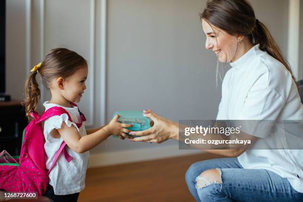 mum putting lunch box with healthy food in backpack - school lunch stock pictures, royalty-free photos & images