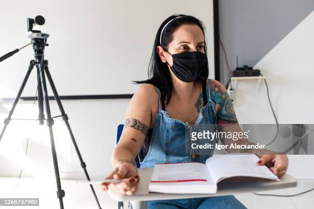 frau trägt schwarze maske im klassenzimmer - woman interview stock-fotos und bilder