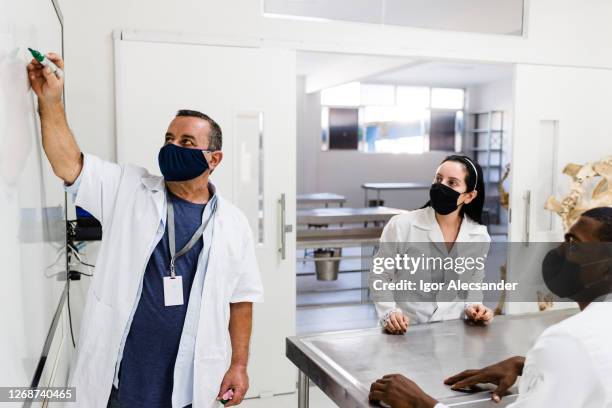 meeting in the laboratory wearing a mask - employee engagement mask stock pictures, royalty-free photos & images