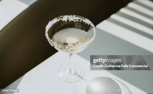 single glass of margarita with salted rim on a shadowy table - マルガリー��タ ストックフォトと画像