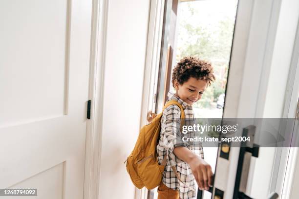 little student closing door behind himself - leaving school imagens e fotografias de stock