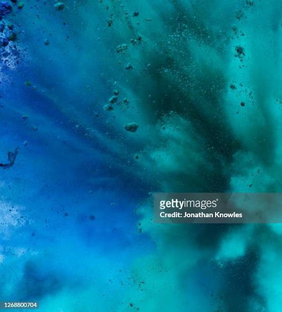 blue and green exploding powder - colorful powder explosion stockfoto's en -beelden