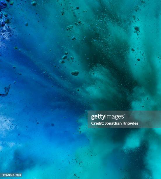 blue and green exploding powder - floating particles stock pictures, royalty-free photos & images