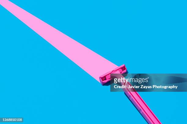 pink razor blade on blue background - かみそり ストックフォトと画像