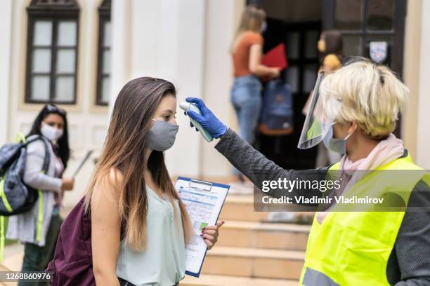 schüler kehren unter coronavirus-bedingungen zur schule zurück - fieberkontrolle stock-fotos und bilder