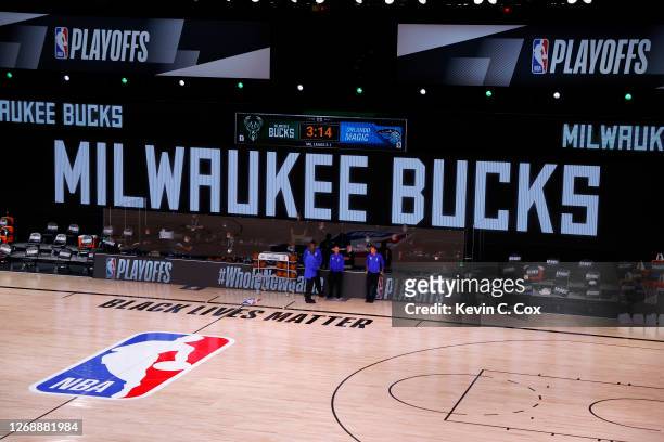 Referees stand on an empty court before the start of a scheduled game between the Milwaukee Bucks and the Orlando Magic for Game Five of the Eastern...
