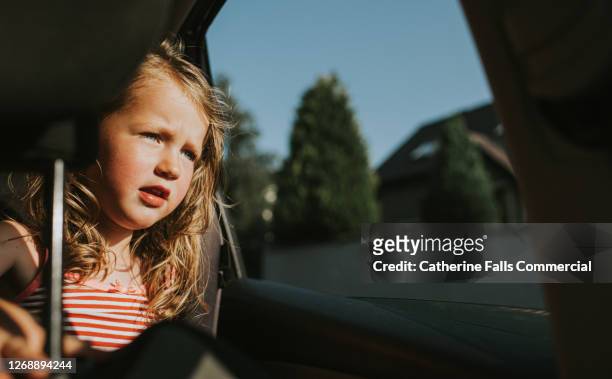 girl in the back seat of a sunny car, looking through the open window - inner views stock-fotos und bilder