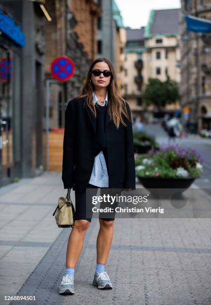 Guest is seen wearing cycle pants, Loewe bag, blazer, sneaker, blue socks on August 26, 2020 in Stockholm, Sweden.