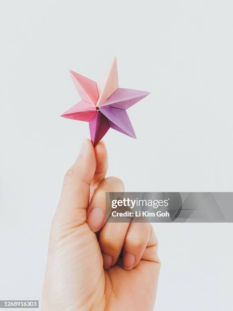 woman hand holding a dominanta star origami - folding origami stock pictures, royalty-free photos & images