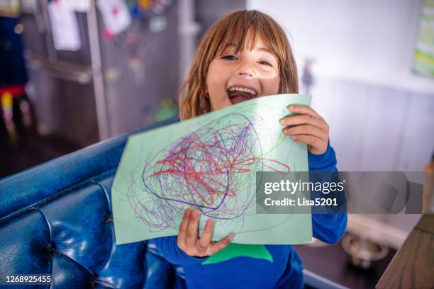 child holds up drawing she made - presunçoso imagens e fotografias de stock