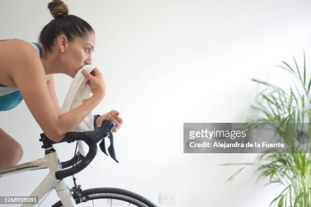 woman on a stationary bike. - heimtrainer stock-fotos und bilder