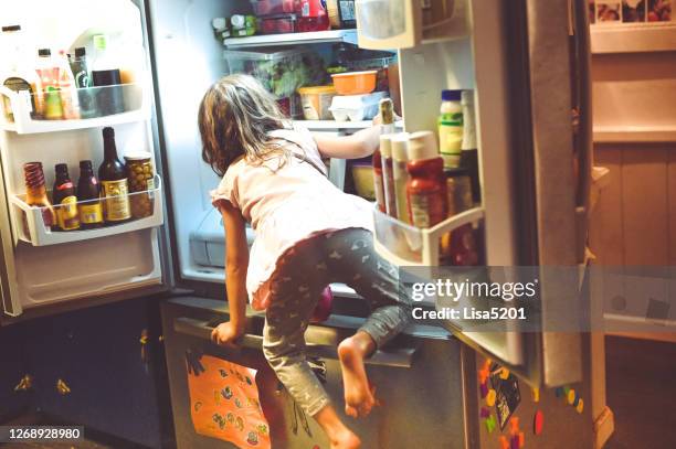 barn klättrar in i familjens kylskåp - resourceful bildbanksfoton och bilder
