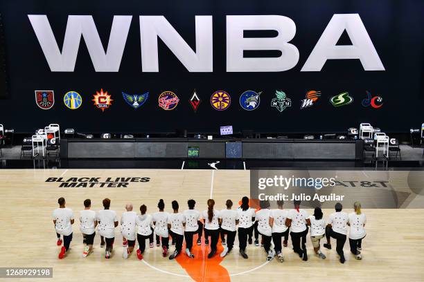 After the WNBA announcement of the postponed games for the evening, the Washington Mystics each wear white T-shirts with seven bullets on the back...