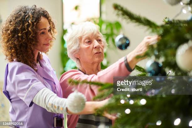 dressing the tree in the care home - christmas mug stock pictures, royalty-free photos & images