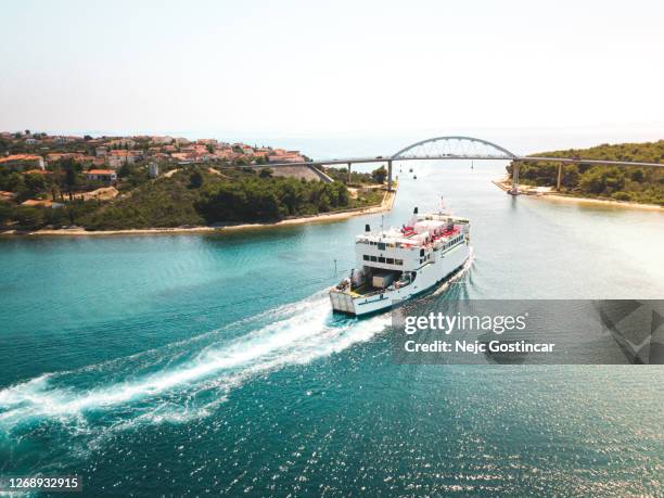 vue aérienne d’un bateau de ferry avec des voitures chargées naviguant sous le pont de route au-dessus du passage de narrov - ferry photos et images de collection