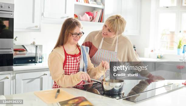 cooking for mum - down syndrome cooking stock pictures, royalty-free photos & images